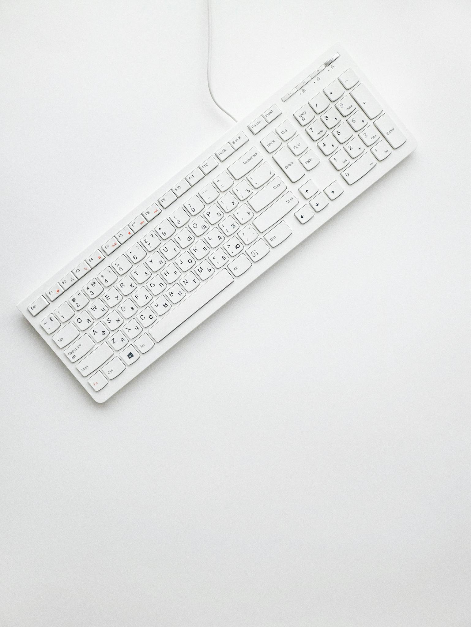 A modern white keyboard on a white background showcasing minimalist design and clean aesthetics.